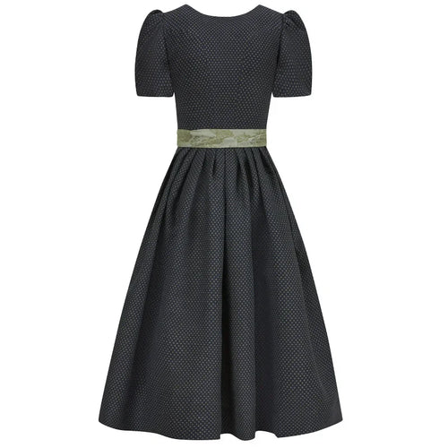 Black polka dot dirndl dress with a green belt on a white background 