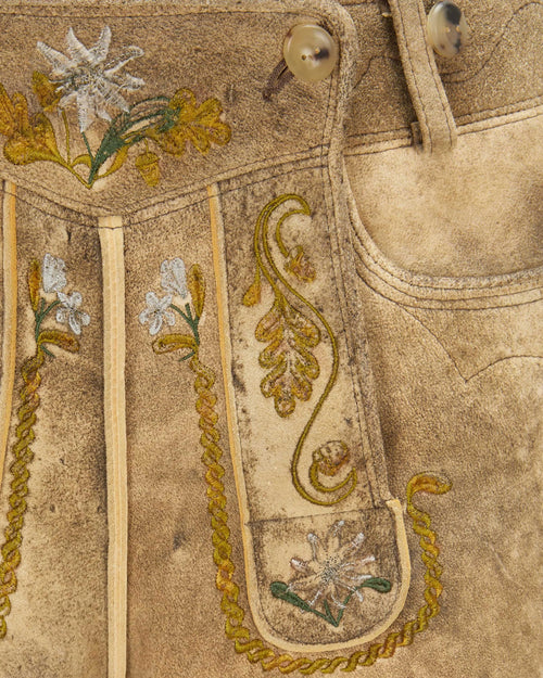 Close-up of embroidered fabric with floral patterns on a beige background