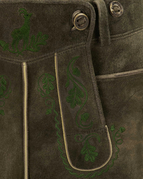 Brown leather jacket with green embroidered designs on a dark background