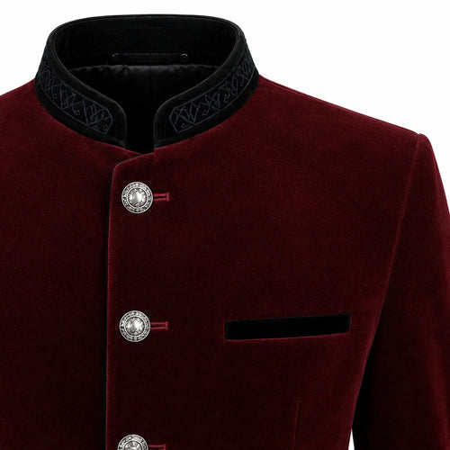 Close-up of a men's traditional-style jacket in deep burgundy velvet with a black mandarin collar featuring embroidered detailing, silver-tone decorative buttons, and a black chest pocket on a white background.