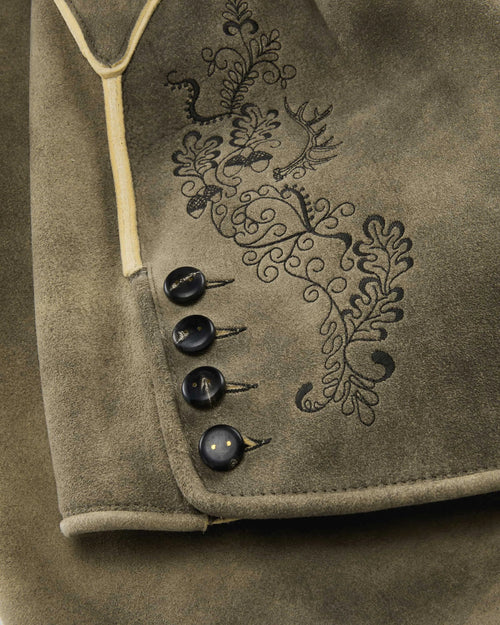Close-up of a brown fabric with embroidered design and buttons.