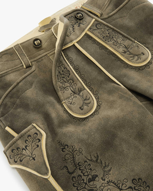 Brown leather pants with decorative stitching on a white background